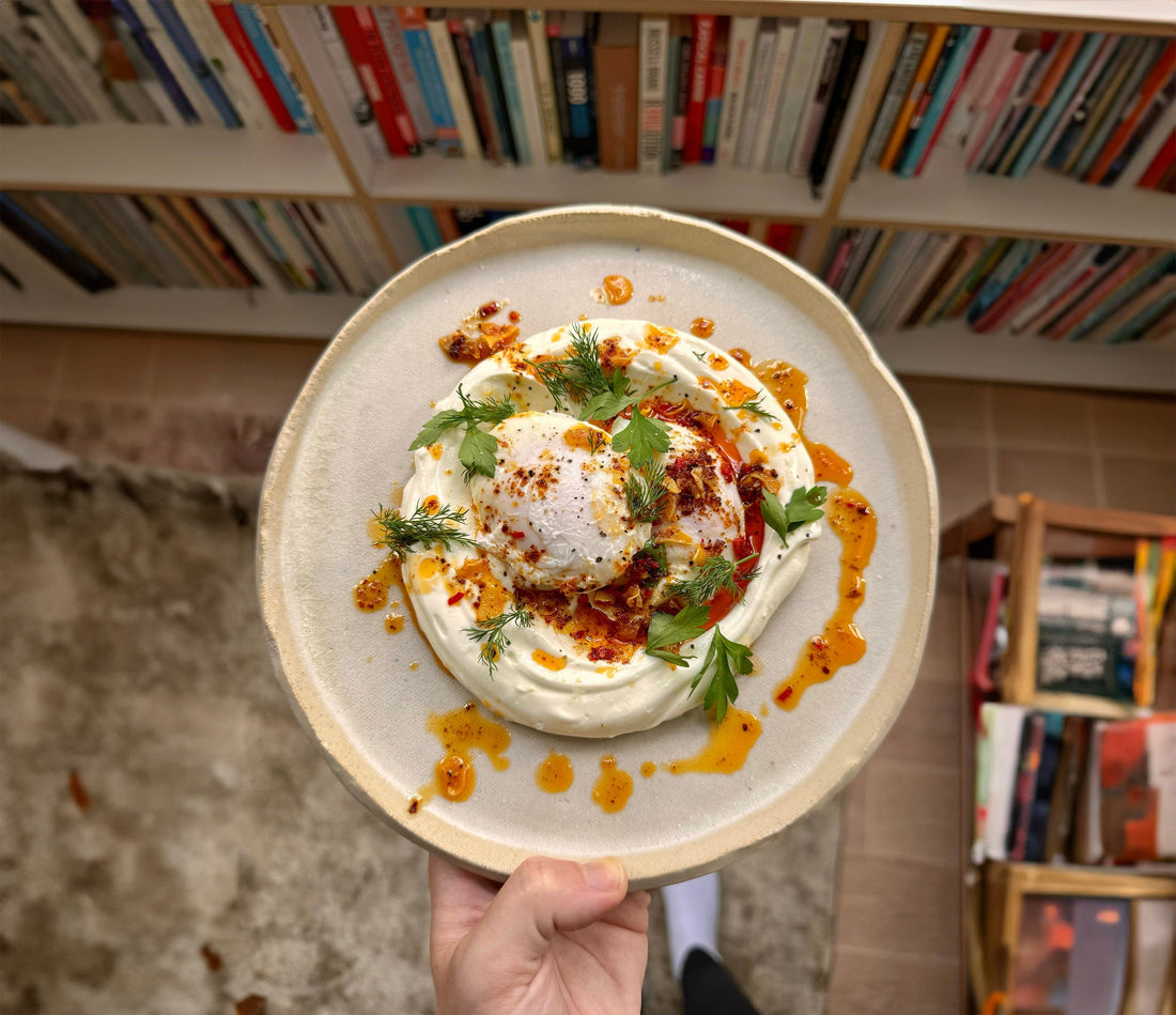 Turkish eggs with garlic yoghurt, poached eggs, and Aleppo chilli ghee, served with fresh herbs